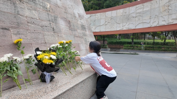 屈美芸在烈士纪念碑前献花。诸侯快讯ok1122官网美术学院供图